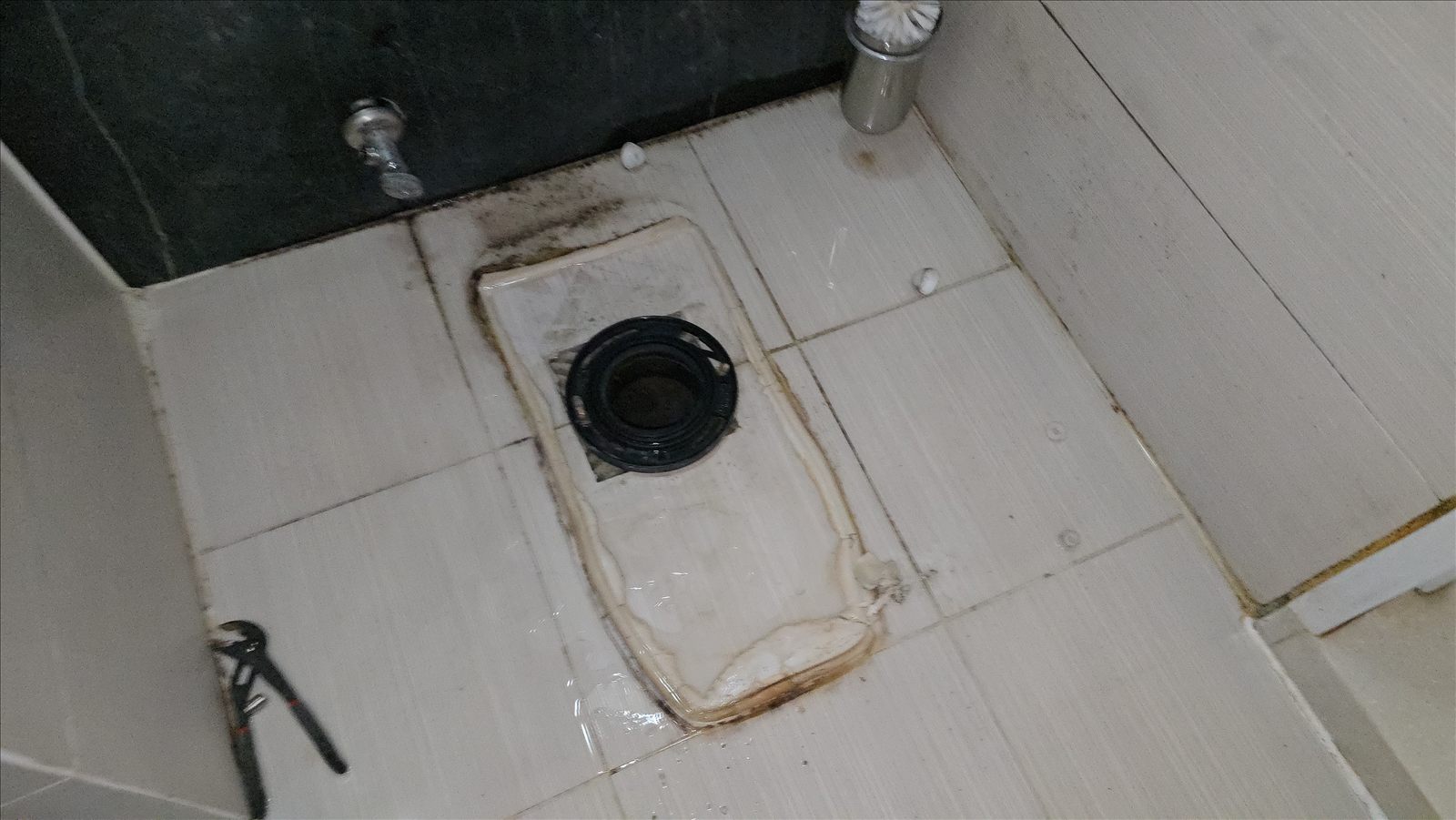 변기를 탈거하자 드러난 바닥 배수 관통부와 주변의 물 자국